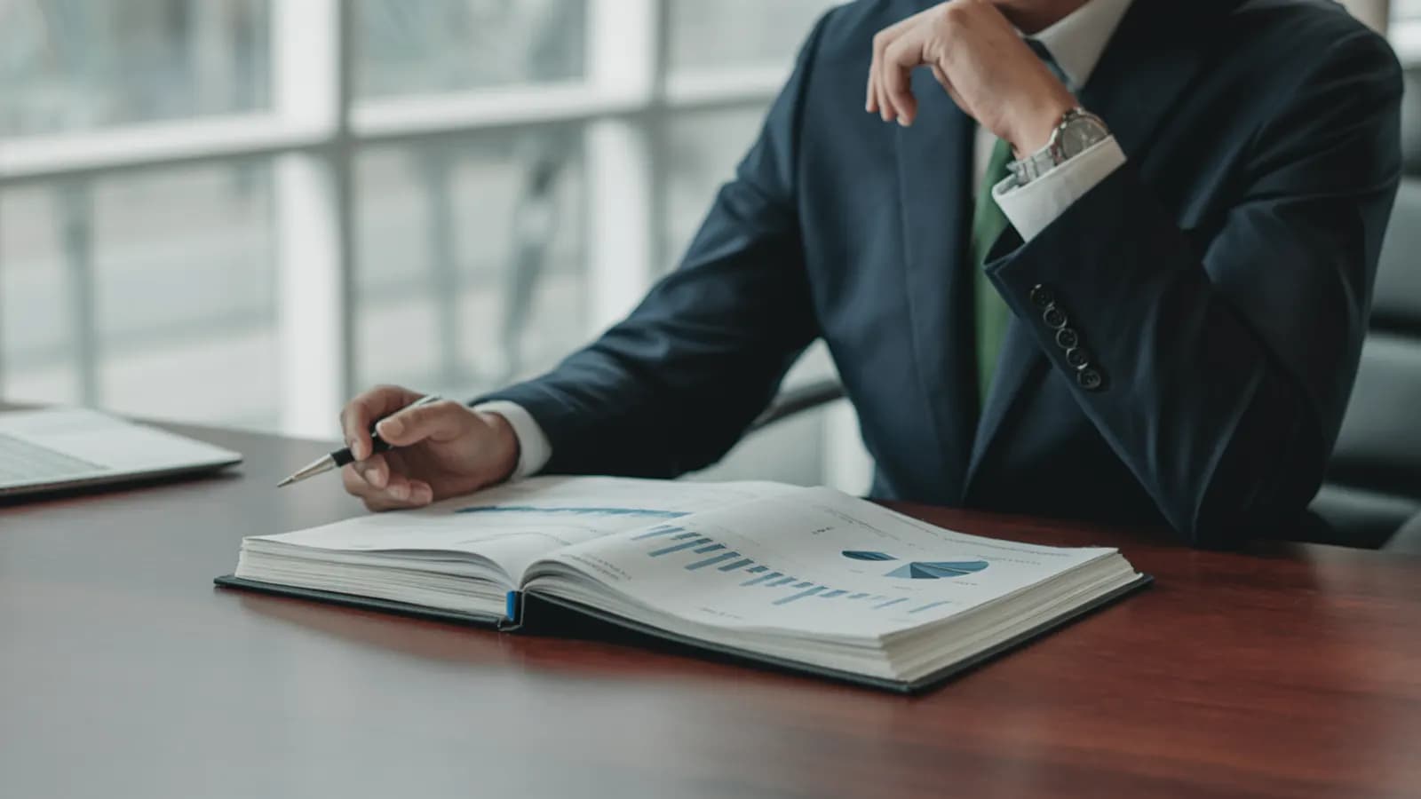 Analyst reviewing a bound quality of earnings report with financial charts